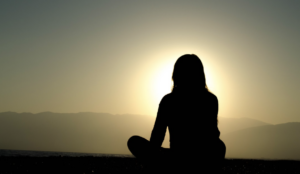 Woman watching sunrise and dealing with anxiety without alcohol